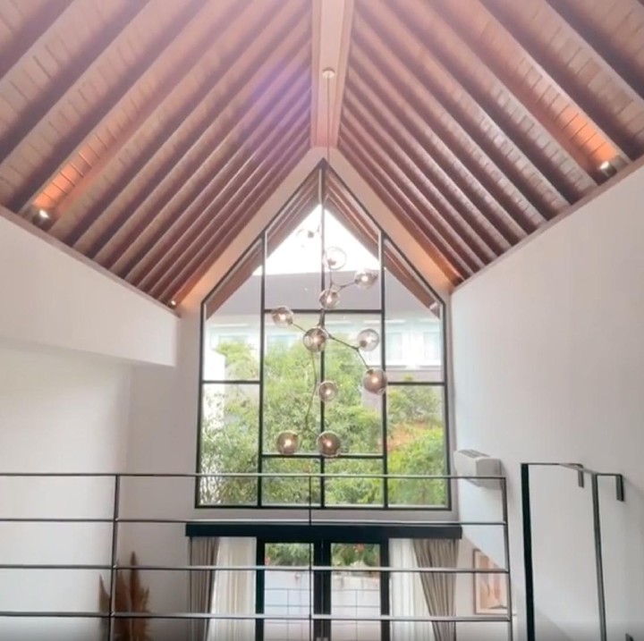 <p>Uniknya ruang menonton televisi yang memiliki langit-langit tinggi ini juga dilengkapi dengan loft lho, Bunda. (Foto: Instagram @hamishdw)</p>