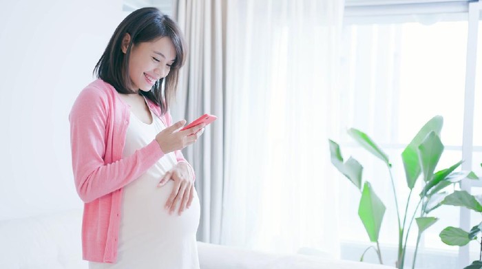 pregnant woman use smart phone at home