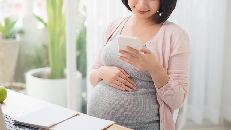 Young pregnant woman working in home office