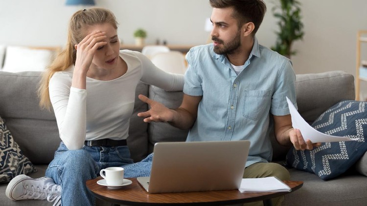 Stressed unhappy couple arguing about huge expenses with laptop and papers, angry husband blaming wife of overspending debt, family having conflict fight about wasting money financial problem at home