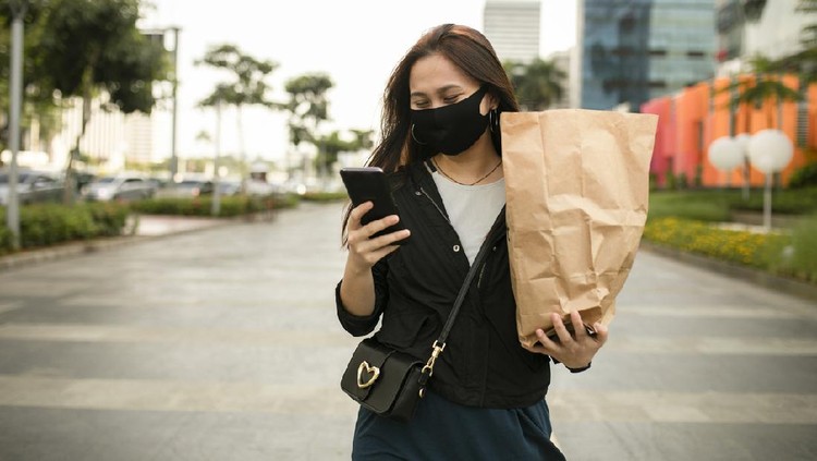 asian woman using phone when walking on the street
