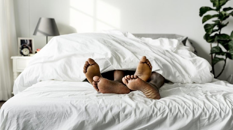 Black couple lying on bed together sex concept
