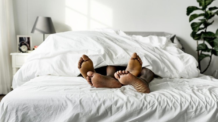 919439074 Black couple lying on bed together sex concept