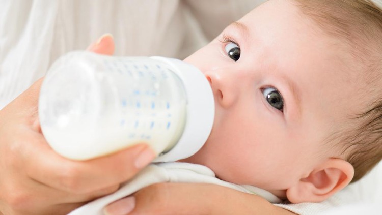 Ilustrasi memberikan ASI dengan botol A detail shot of cute baby drinking milk from bootle