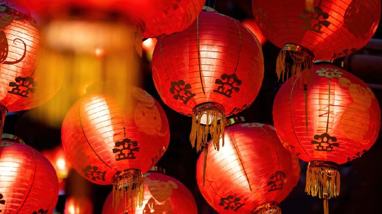 Rows of colorful glowing red Chinese lanterns hanging high across the street during Chinese New Year Celebrations.
