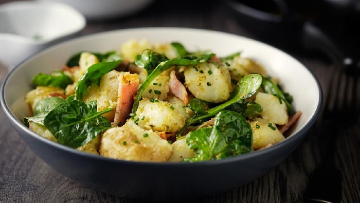 Home made freshness crashed baby potatoes salad with spinach and chopped bacon and green pesto sauce