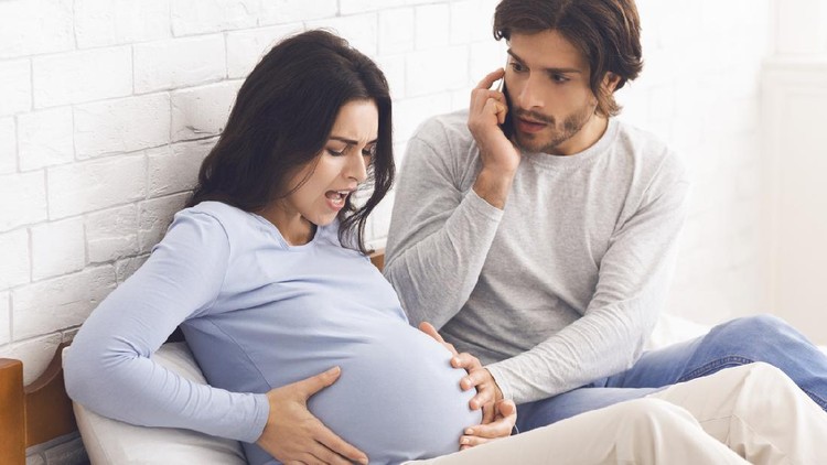 Time To Give Birth. Pregnant Woman Having Contractions At Home, Her Panicked Husband Calling Doctor, Free Space