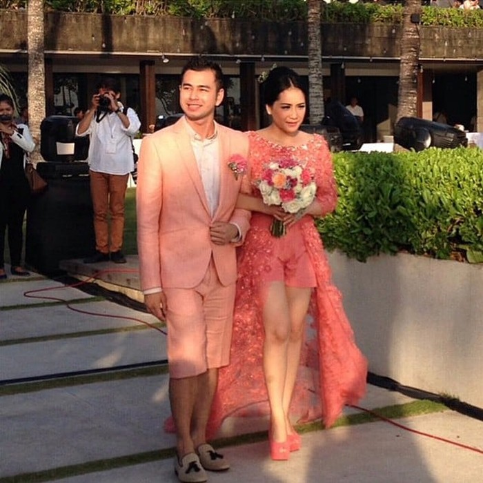 Jika Sherina mengenakan celana panjang, Nagita Slavina tampil unik dengan memadukan kebaya modern dan celana pendek saat menggelar resepsi pernikahan di Bali tahun 2014 silam. Tak kalah unik, sang suami, Raffi Ahmad juga mengenakan setelan jas yang dipadukan dengan celana pendek selutut dan sepatu sneakers. Acaranya yang mengusung konsep beach party membuat kedua mempelai memilih tampil sedikit santai. (Foto: instagram.com/rans_family.1717)