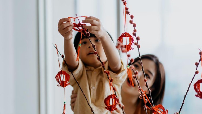 Multi-generation Asian Chinese family greeting friends and relatives with video call on laptop computer in Chinese New Year during global pandemic.