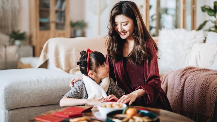 Multi-generation Asian Chinese family greeting friends and relatives with video call on laptop computer in Chinese New Year during global pandemic.