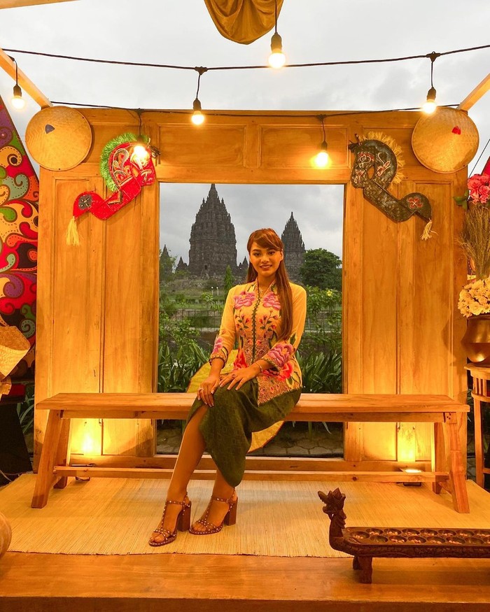 Saat berlibur ke Prambanan, Jawa Tengah, Aurelie juga memakai pakaian tradisional setempat dengan kebaya modern. Dia tampil dengan paduan kebaya warna hijau-kuning yang dipadu dengan heels, serta rambut digerai/Sumber/Instagram/aurelie.hermansyah.