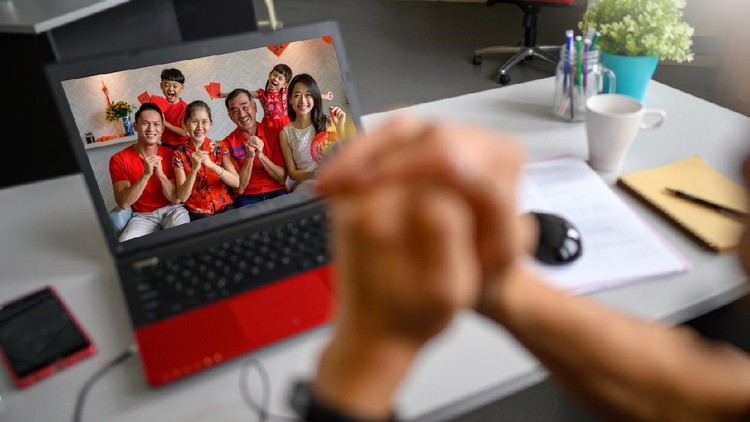Tahun Baru China 2021 Multi-generation Chinese family greeting friends and relatives during Chinese New Year with video call on laptop computer during lockdown and MCO (movement control order) on global pandemic. Covid-19 and Coronavirus, 5G & Wireless Technology, Chinese New Year Celebration and Chinese Traditional Festival, Family Bonding and Togetherness Concepts.