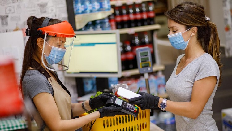 Female customer doing a contactless payment at the supermarket