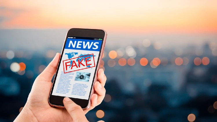 Ilustrasi Berita Hoaks Hands holding mobile phone on blurred night city as background
