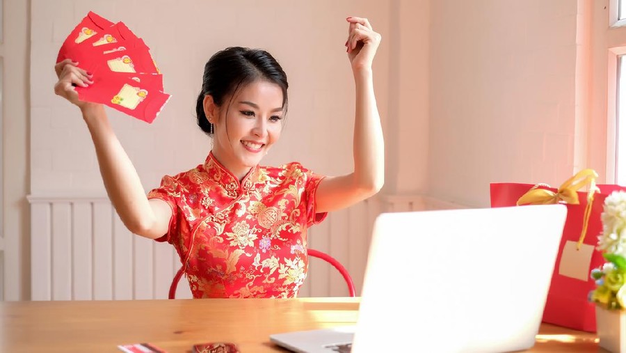 Happy chinese new year. asian woman showing angpao in the office smile happily.