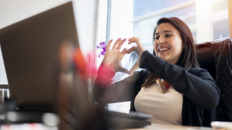 Ilustrasi Hari Valentine Woman at office video chatting, and making heart shape
