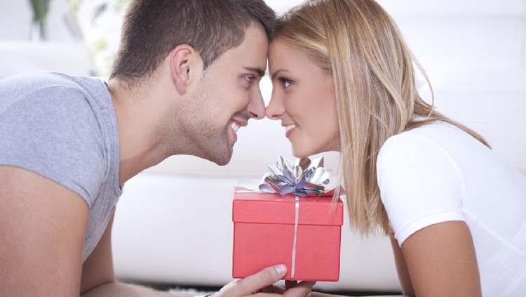 Close up of beautiful young couple and red box gift between them.