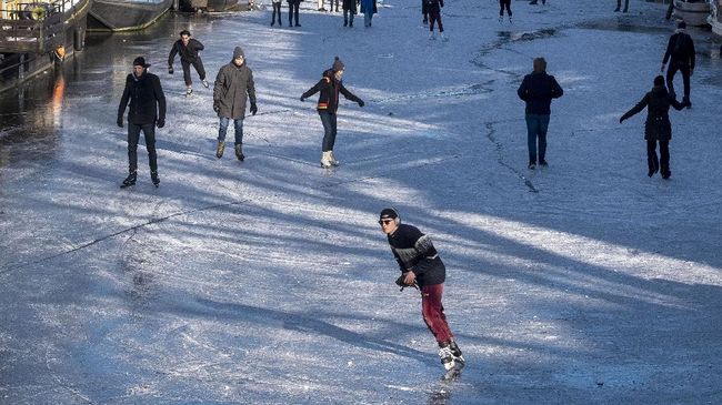 Girangnya Warga Amsterdam Berseluncur di Kanal yang Membeku Untuk yang pertama kali sejak 2018 kanal Prinsengracht, di Amsterdam, Belanda, membeku. Warga langsung datang untuk main ice skating.