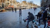FOTO: Pemandangan Kanal di Belanda yang Membeku Kanal Prinsengracht di Amsterdam, Belanda, sempat membeku pada pertengah Februari. Warga langsung berdatangan untuk main ice skating.