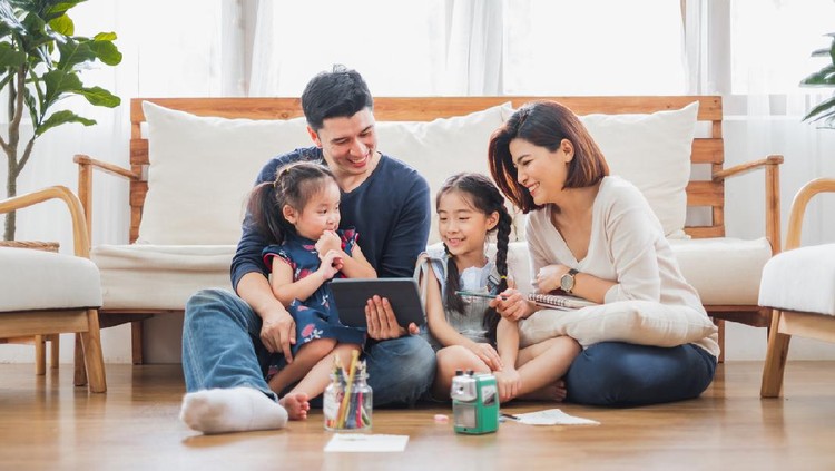 Happy Asian family using tablet, laptop for playing game watching movies, relaxing at home for lifestyle concept