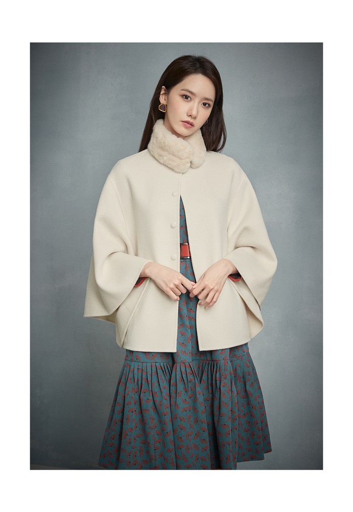 Masih dengan dress bermotif bunga, tetapi kali ini dengan warna motif yang kontras ditambah dengan belt yang warnanya senada dan mantel jubah sebagai outerwear membuat Yoona tampak manis. (Foto: jigott.co.kr)