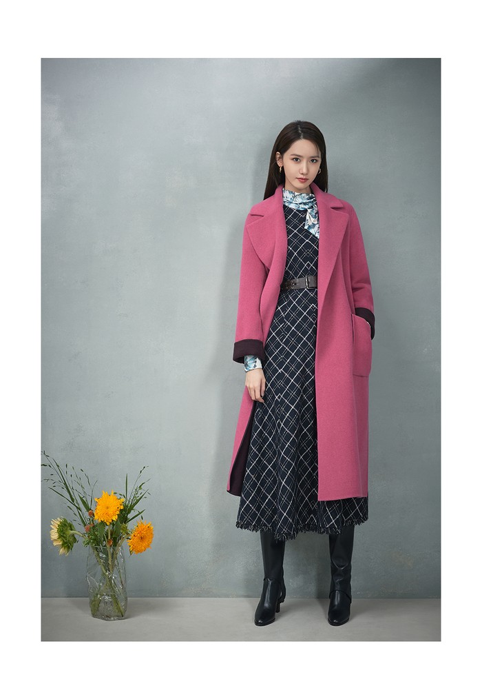 Kali ini Yoona kenakan blouse bermotif daun dan gaun bermotif bordir kotak-kotak, serta mantel bergaya sensasional dengan warna pink. (Foto: jigott.co.kr)
