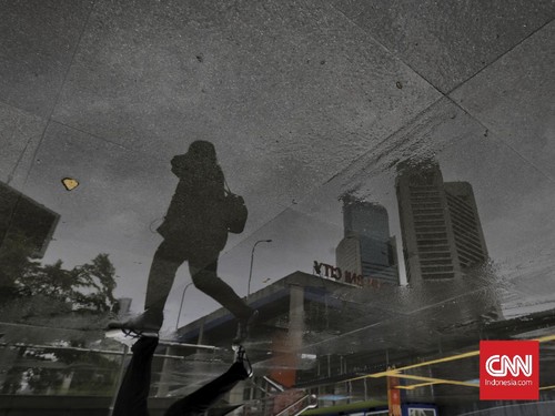Pekerja melintas di kawasan Jalan Sudirman, Jakarta, Selasa, 16 Februari 2021.CNN Indonesia/Adhi Wicaksono
