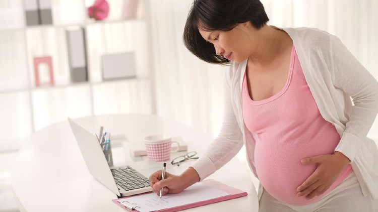 Pretty Vietnamese pregnant woman planning her day