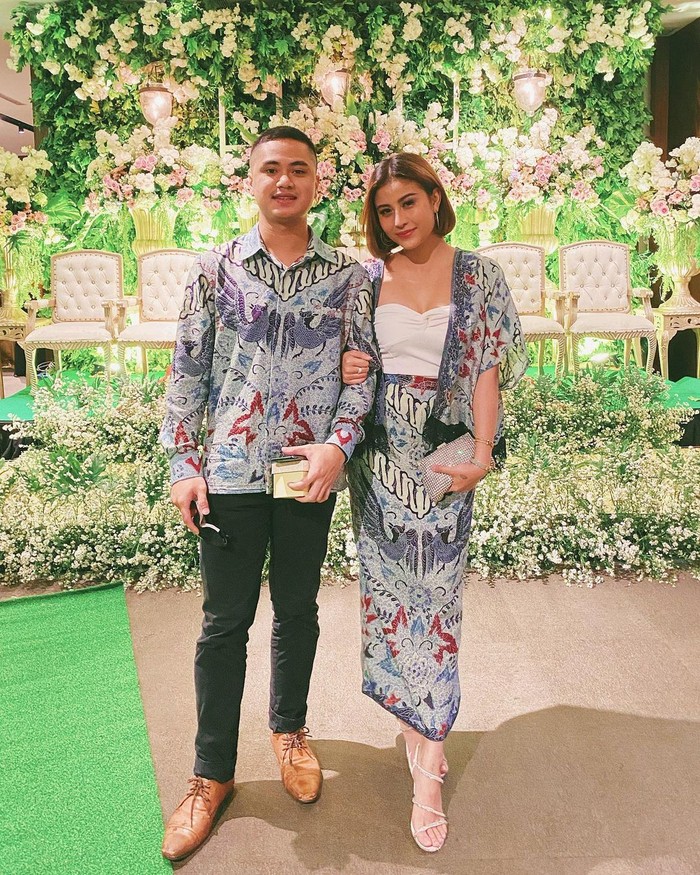 Baju kondangan couple bareng pasangan bisa anti-mainstream dengan meniru outfit ala Awkarin ini, Ladies. Memadukan batik biru sebagai bawahan dengan outer yang diberi inner berbahan satin warna putih (Foto: www.instagram.com/awkarin/).