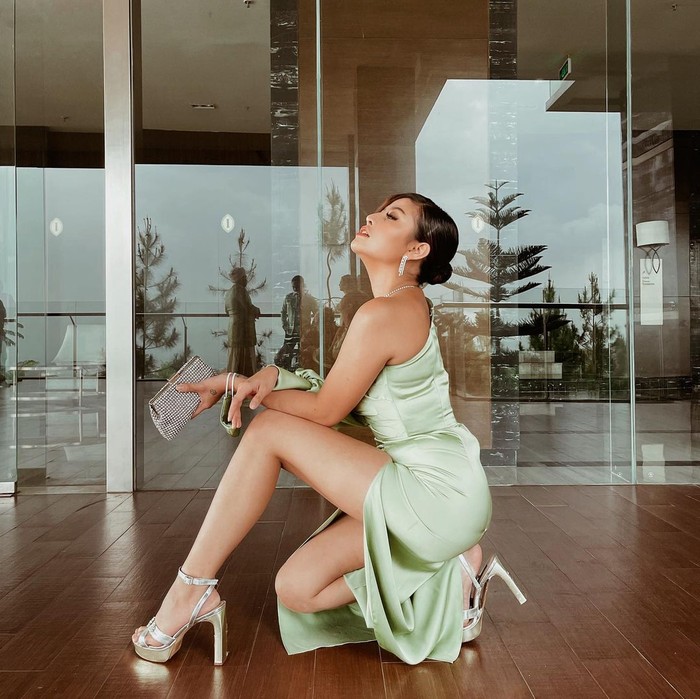 Tampil simpel pakai long dress satin, why not? Meskipun terlihat simpel kamu bisa tetap tampil elegan dengan memilih dress model one-shoulder berwarna hijau. (Foto: www.instagram.com/awkarin/).