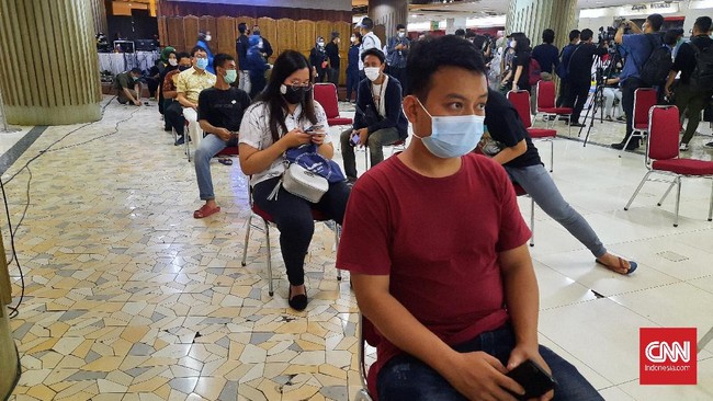 Para pedagang Pasar Tanah Abang yang sudah disuntik vaksin Covid-19 diminta menunggu 30 menit untuk melihat apakah ada efek samping.