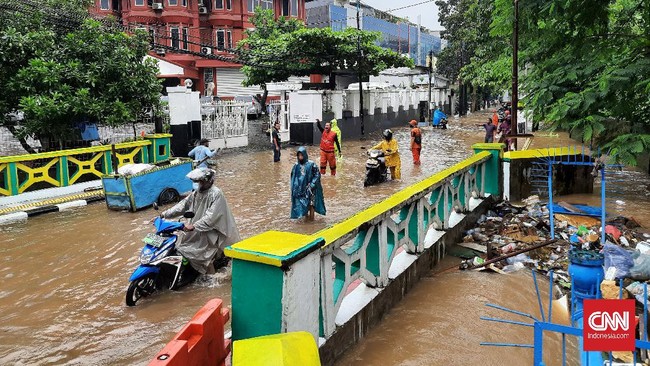 Jalan Pejaten Raya depan pusat perbelanjaan Pejaten Village Jakarta Selatan terputus akibat banjir luapan Kali Mampang, Sabtu (20/2).