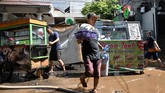 FOTO: Banjir Surut, Warga Mulai Bersih-bersih Masyarakat dan pedagang di ibu kota mulai membersihkan rumah dan tempat usaha mereka yang terendam banjir pada Sabtu (20/2) kemarin.