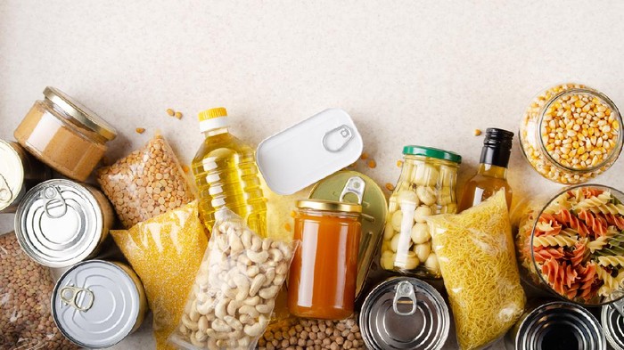 Flat lay view at kitchen table full with non-perishable foods. Spase for text