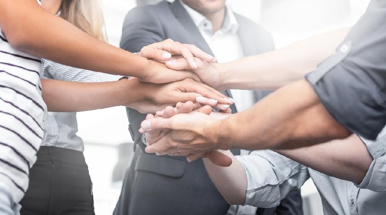 Ilustrasi PNS Close up view of young business people putting their hands together. Stack of hands. Unity and teamwork concept.