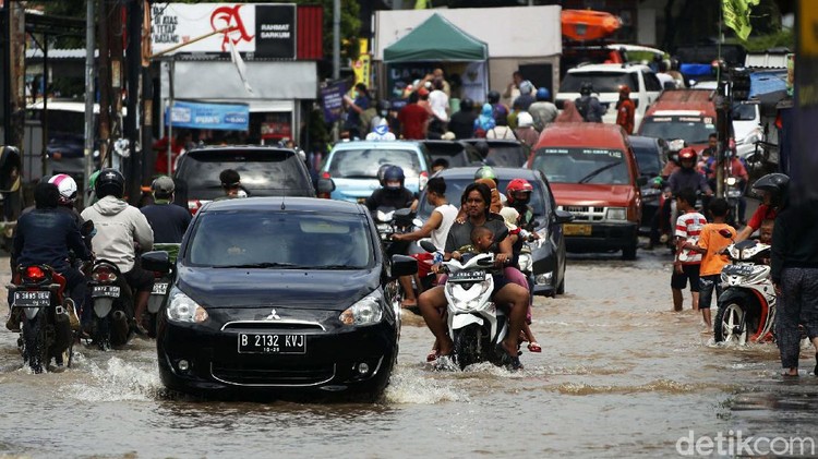 Lalin Tersendat di Jalan Raya Jatimekar Gegara Genangan Banjir masih merendam Jalan Raya Jatimekar, Jatiasih, Bekasi, Minggu (21/2/2021). Akibat genangan tersebut, arus lalu lintas sempat tersendat.