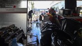 FOTO: Banjir Surut, Warga Mulai Bersih-bersih Masyarakat dan pedagang di ibu kota mulai membersihkan rumah dan tempat usaha mereka yang terendam banjir pada Sabtu (20/2) kemarin.