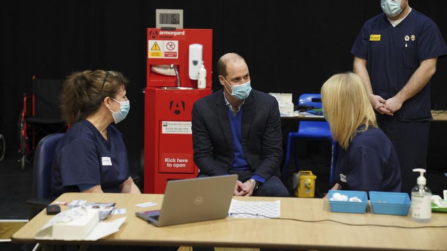 Britain's Prince William, center, speaks to staff and volunteers during his visit to the King's Lynn Corn Exchange Vaccination Centre in King's Lynn, Monday Feb. 22, 2021. (Arthur Edwards/Pool via AP)