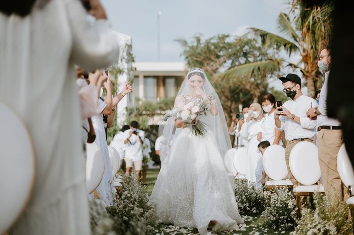 Sementara untuk resepsi, Wendy mengenakan gaun modern berwarna putih lengkap dengan kain veil yang menutupi wajah dan menjuntai indah ke belakang. Gaun yang dikenakannya ini merupakan rancangan dari desainer Cynthia Tan. (Foto: instagram.com/wendywalters)