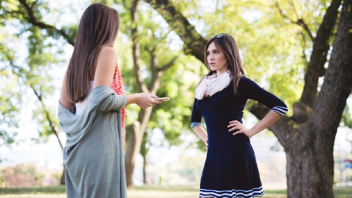 Two female friends having disagreement in a park