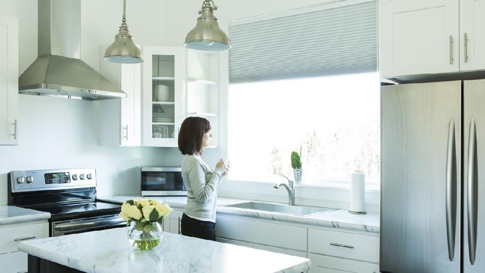 small kitchen in a pool guest house with appliances and cabinets and a counter and custom lighting
