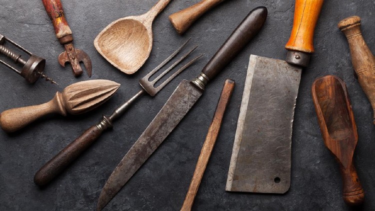 Vintage kitchen utensils, butcher, knife, fork over stone board. Top view