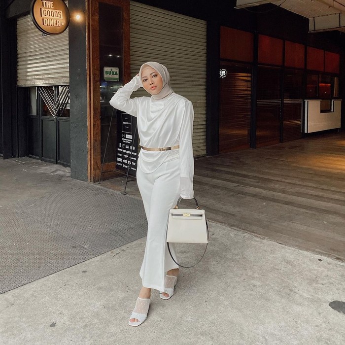 Tampil formal dengan pakaian berwarna putih memang nggak pernah gagal! Gaya satu ini bisa kamu contek dengan memadukan lyon top dan vanilla pants. Detail belt dan tas yang serasi bikin aura kamu semakin terpancar. (Foto: instagram.com/rachelvennya)