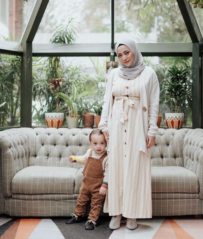 Kalau kamu suka yang kalem-kalem, dress ini cocok juga masuk daftar contekan! Detail vertikal cream yang senada dengan outer sangat pas disandingkan hijab abu-abu. Meski sederhana outfit putihmu tetap nggak mengecewakan. (Foto: instagram.com/rachelvennya)