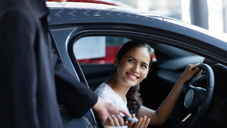 Beautiful asian woman buying a car at the showroom