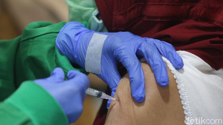 Vaksinator menyuntikkan vaksin COVID-19 kepada warga kelompok lanjut usia (lansia) saat vaksinasi massal di SMA Negeri 8 Jakarta, Tebet, Jakarta Selatan, Senin (1/3).