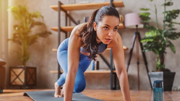 Young woman doing sport exercises indoor at home