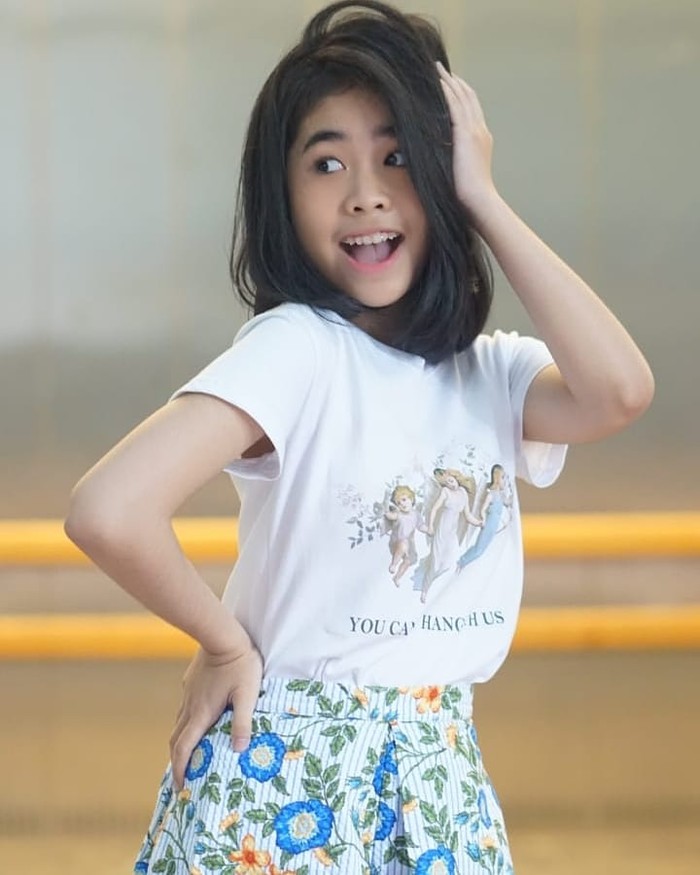 Perpaduan kaos pendek dan celana floral juga bikin kamu terlihat lebih cheerful, Ladies. Kamu cukup memadukan kaos pendek putih dengan celana floral warna biru yang cerah (Foto: www.instagram.com/alifalubis/).