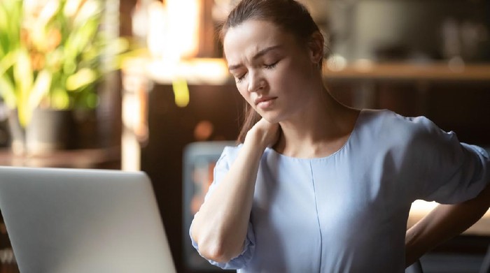 Stressed upset business woman feeling backpain working on laptop sitting in incorrect posture, tired fatigued student rub back suffer from spine muscular pain injury lumbar backache concept in office