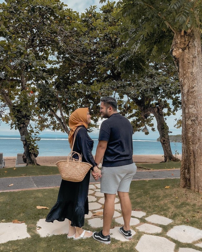 Dunia bagaikan milik berdua, Kesha dan Adhi berpegangan tangan di tepi pantai dengan warna laut yang biru. (foto: instagram.com/kesharatuliu05)